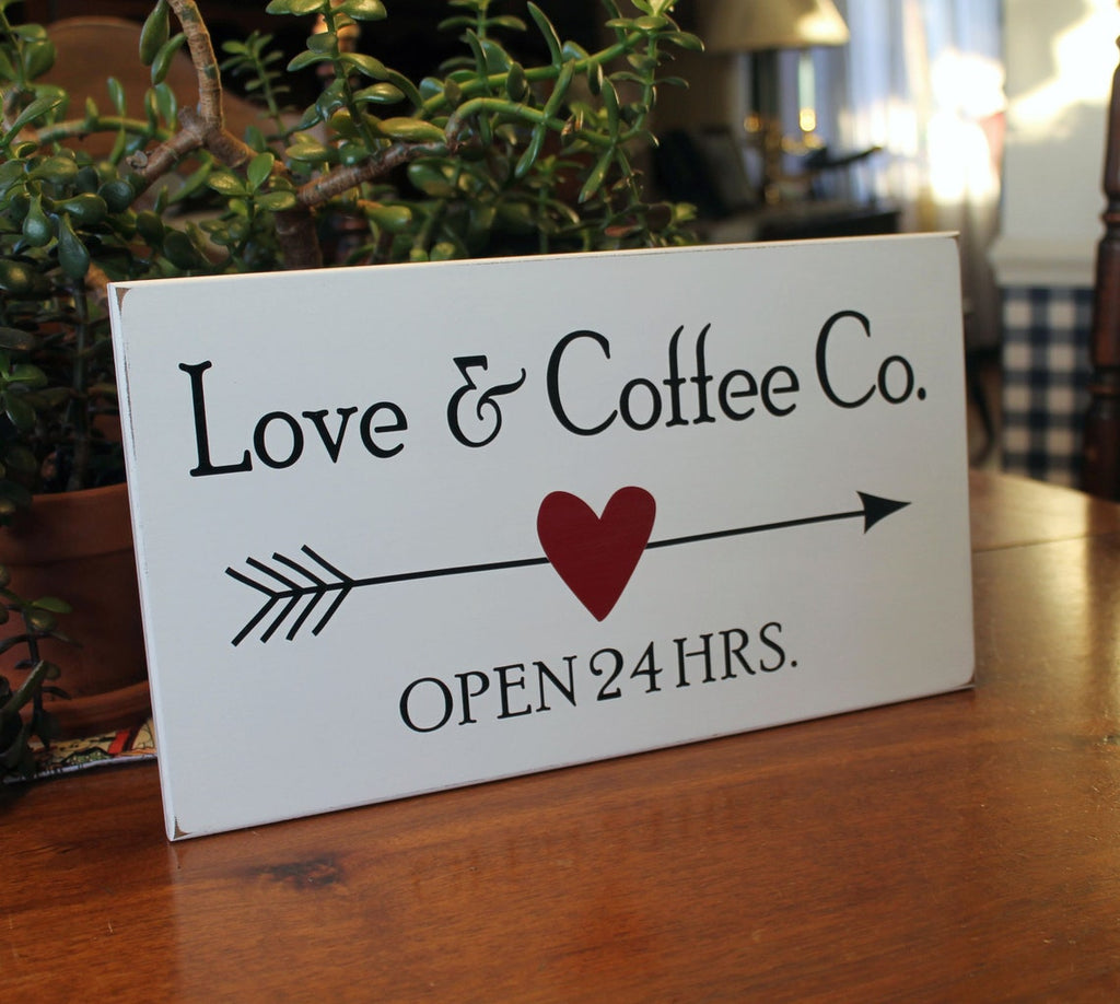 Love and Coffee Co on a white worn finish 8x14 inch sign.  Black letters with an arrow going through a burgundy color heart. 