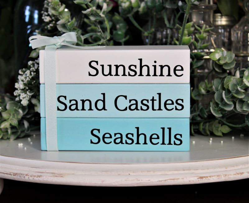 Sunshine Sand Castles Seashells Stack set of 3 wood blocks glued together and tied with a bow. White, aqua and pale aqua blocks with black lettering. Faux book stack. 3 1/2 inches tall, 5 inches across and 2 1/2 inches deep. #beachdecor Country Workshop.