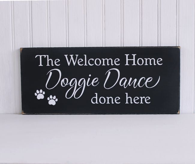 A black worn finish wood sign with with wording that says The Welcome Home Doggie Dance done here.  Also has two paw prints on the bottom left corner.  Several sizes and colors.
