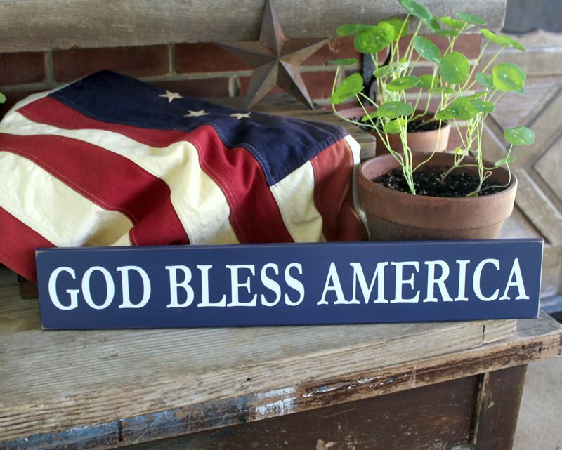 White lettering on a dark blue worn finish  wood sign saying God Bless America.  Sign available in several sizes and colors.