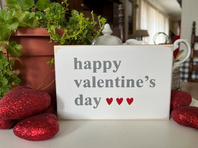 Happy Valentine's Day Wood Sign. Worn white with gray letters and 3 small red glittered hearts. Sign measures 4x6 inches. Hand painted tiered tray decor.