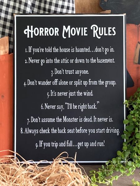 12x16 inch black worn finish sign.  White lettering and border.  Horror Movie Rules.  A list of 9 rules to follow if you are watching or in a horror or spooky movie.  