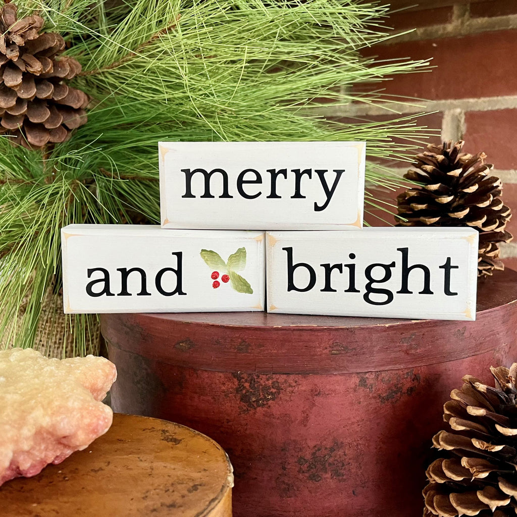 Set of 3 mini blocks.  Worn white with black lettering saying merry and bright with hand painted holly leaves.