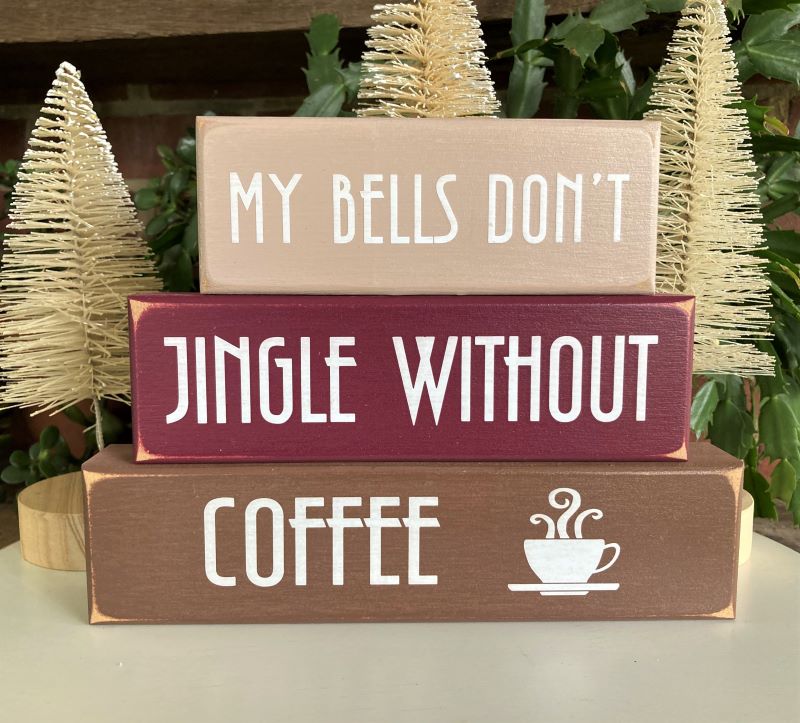 My Bells Don't Jingle Without Coffee. Set of 3 wood blocks with a painted worn finish. 6 3/4 h x 9 w x 1 1/2 inches. Tan, Burgundy, Brown with white lettering.Tuck on a shelf, sit on a desk or display on a tiered shelf for a bit of Christmas decor