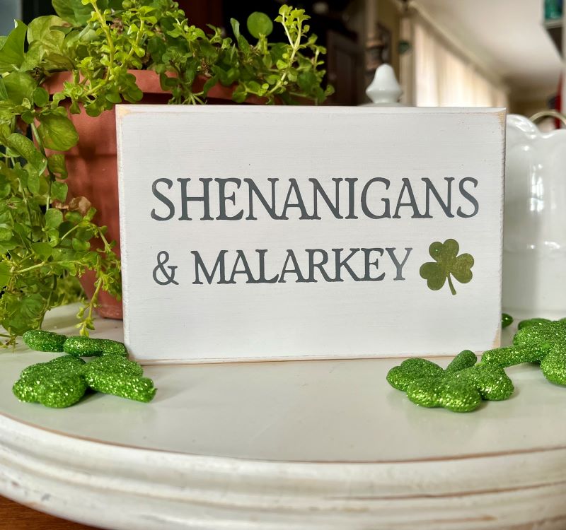 Shenanigans and Malarkey mini sign.  4x6 inches .  White worn finish with gray lettering and a green glittered shamrock.  Tiered tray  decor for St Patrick's Day. 