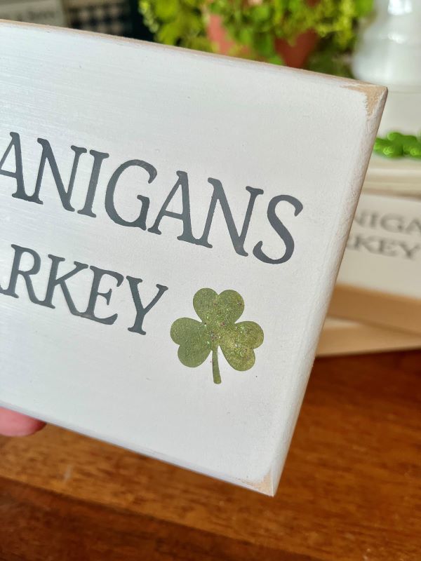 Shenanigans and Malarkey mini sign. 4x6 inches . White worn finish with gray lettering and a green glittered shamrock. Tiered tray decor for St Patrick's Day.