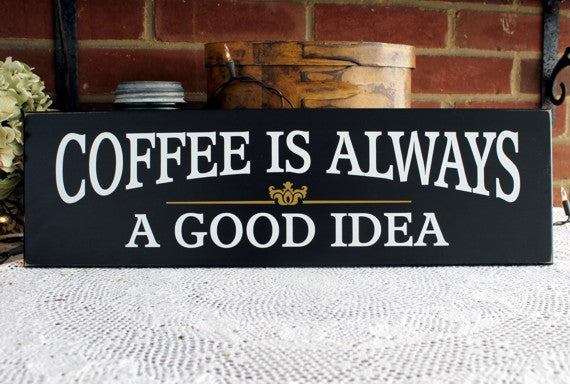 A black painted wood sign with white wording Coffee is always (first line) a good idea (second line). There is a gold florish between the two lines.  The sign measures 6x20 inches. Handcrafted.