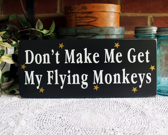 6x14 inch sign.  Black with white wording saying Don't make me get my Flying Monkeys.  Gold stars are around the wording. 