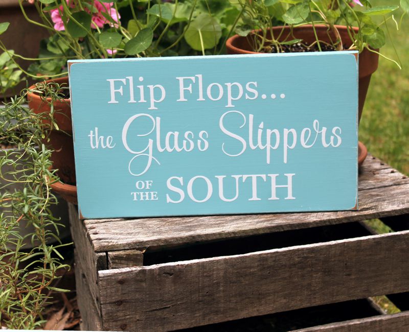 8x14 inch worn finish aqua sign with white wording that says Flip Flops The Glass Slippers of the South.