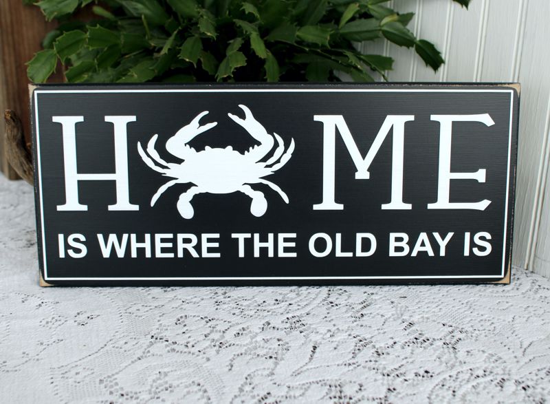 Home is where the Old Bay is white lettering with a crab as the O in home.  black worn finish sign.  Available in several sizes and colors.  countryworkshop.net 