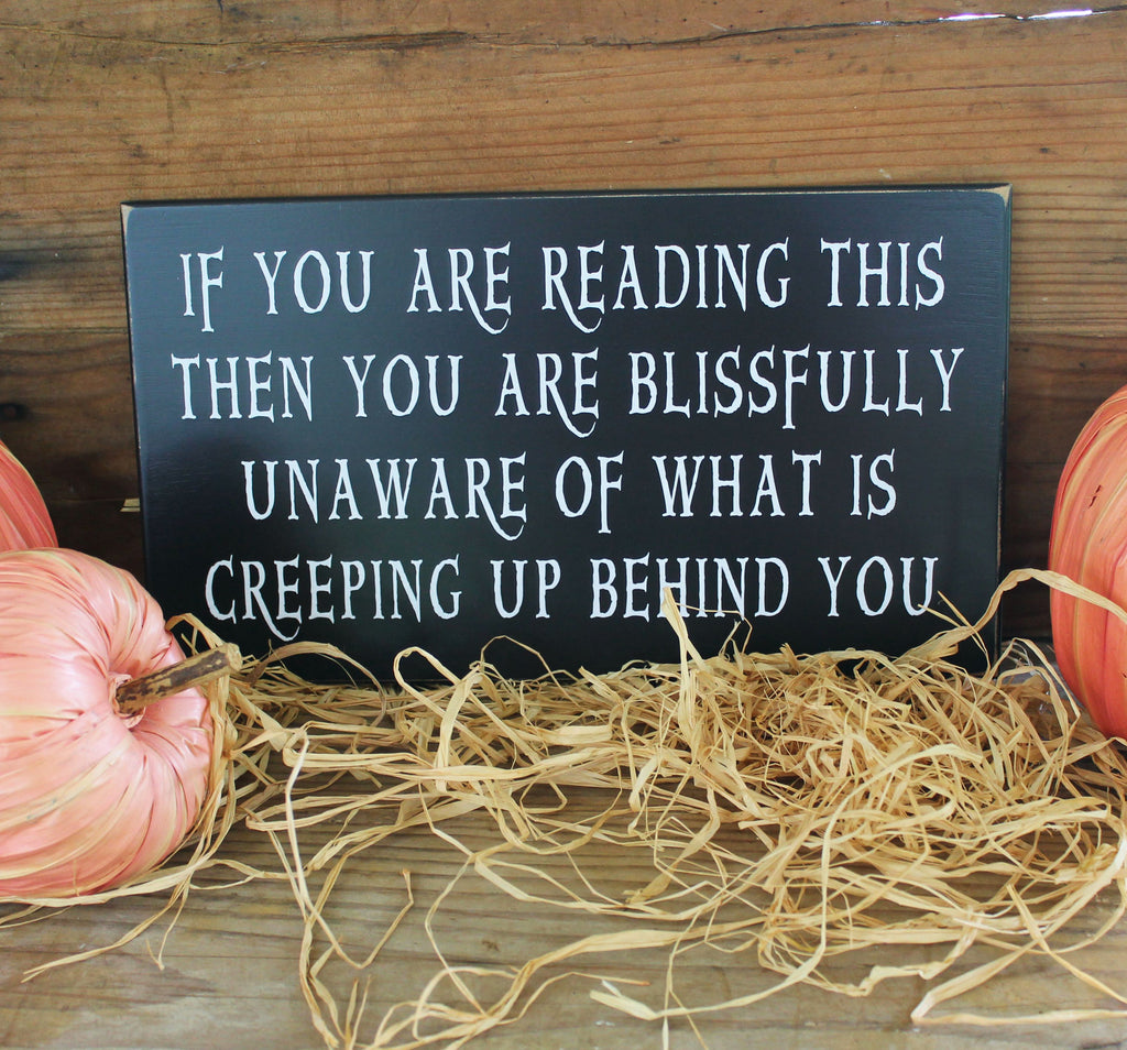 Halloween Wood Sign.  Black with white wording that says, "If you are reading this then you are blissfully unaware of what is creeping up behind you.  Sign is available in 2 sizes. 8x14b inches or 10x20 inches.  Country Workshop signs.