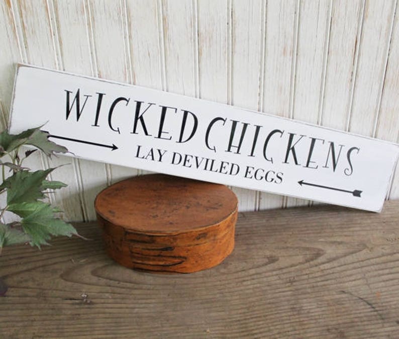 Worn finish white wood sign with black lettering that says Wicked Chickens Lay Deviled Eggs.  Sign available in 2 sizes. 